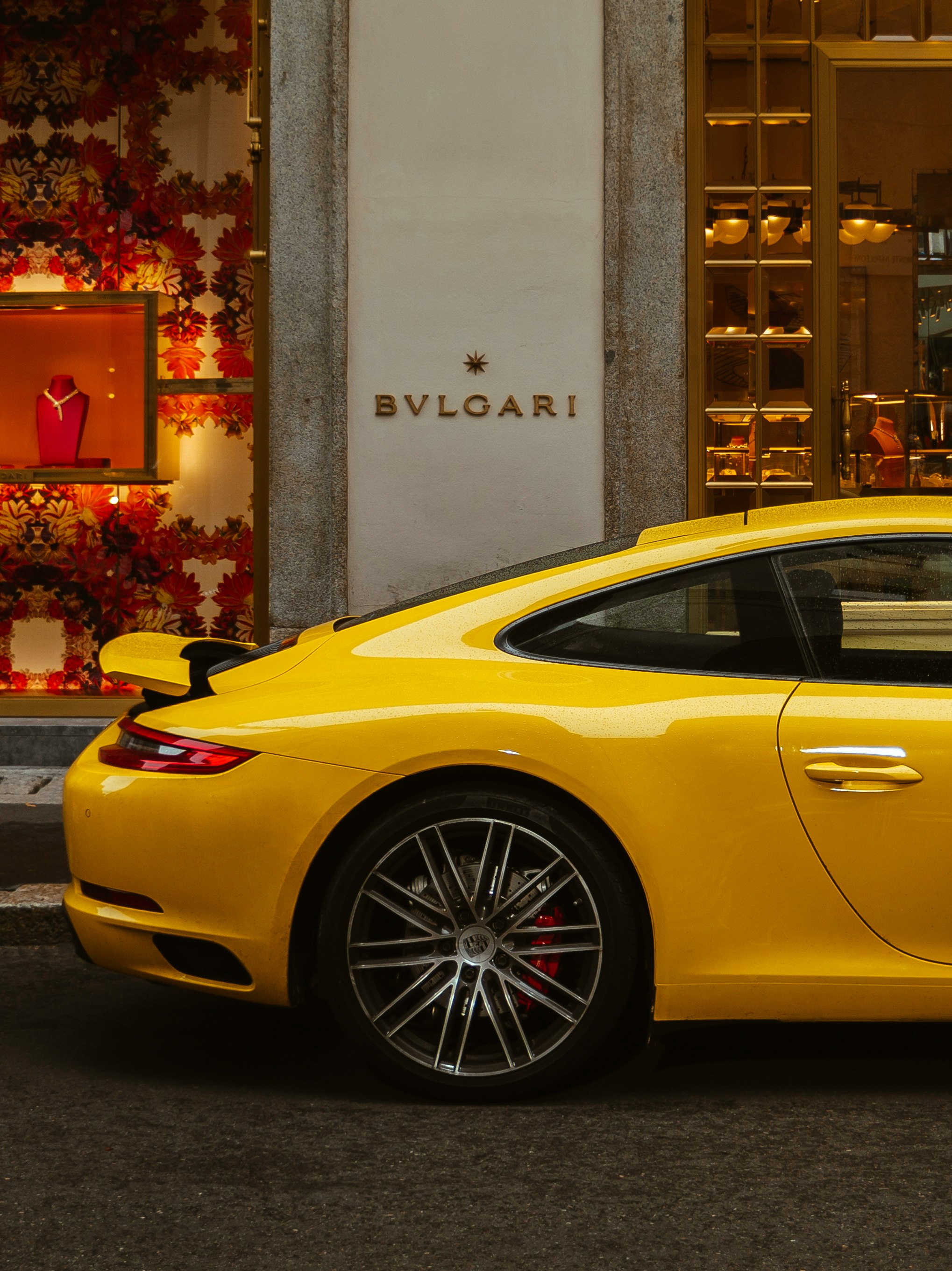 yellow porsche 911 parked near building